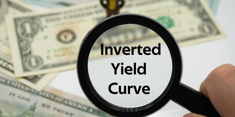 Magnifying glass with words "inverted yield curve' written inside it