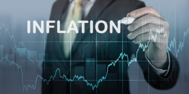 Businessman,Writes,Word,Inflation,Against,Background,Of,Graph,Chart,Of