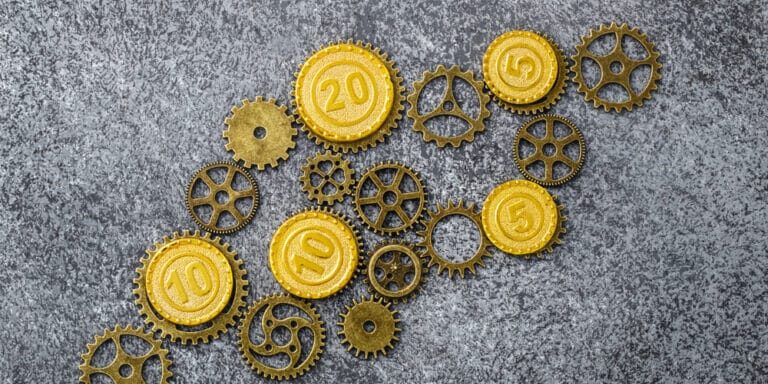 Golden,Coins,Gears,On,Gray,Stone,Background.,Monetary,Gold,Is