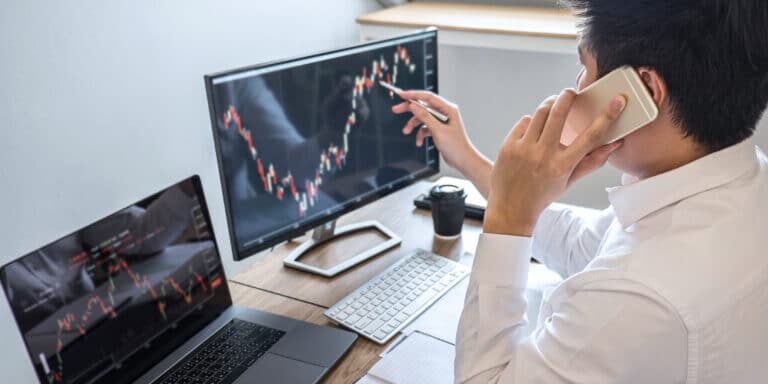 A man on his computer looking at stocks.