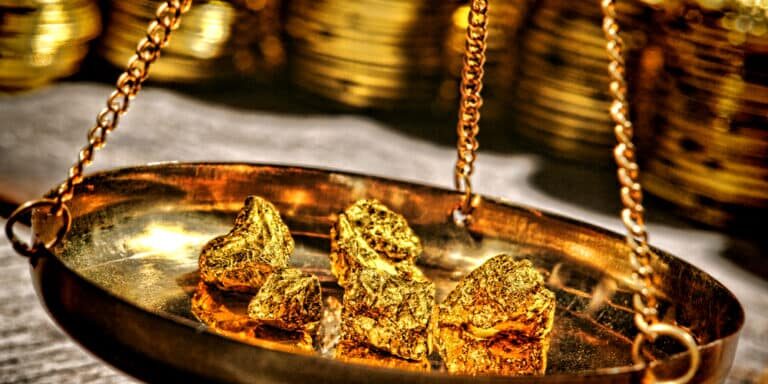 Gold nuggets being being weighed on a weight balance.