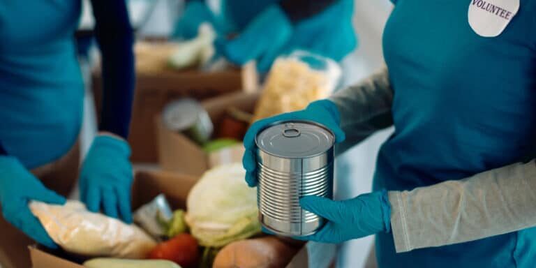 Unrecognizable,People,Packing,Food,In,Donation,Boxes,While,Working,As