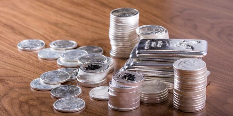 Closeup,Of,Silver,Bars,And,Silver,Coins,Stacked,On,Wooden