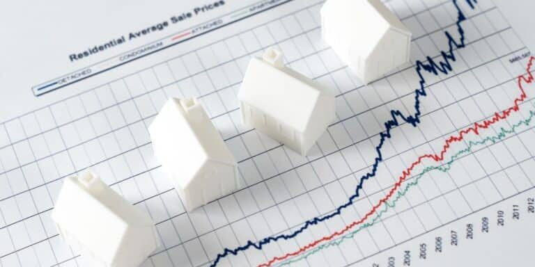 White,Miniature,House,Models,On,Graph,Indicating,Growth,In,Real