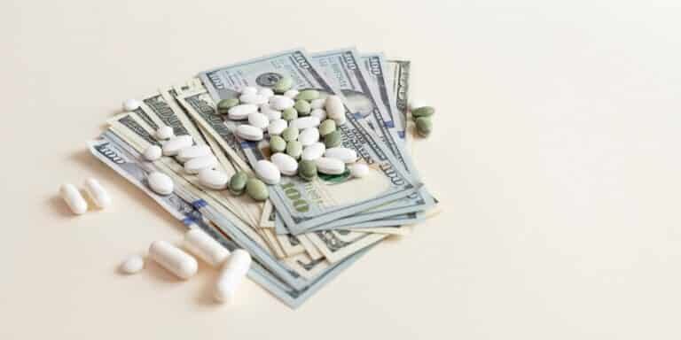 Closeup,Many,Dollar,Money,Banknotes,And,Different,Pills,Or,Tablets.
