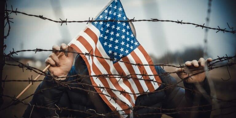 Man,Holding,American,Flag,Near,A,Barbed,Wire,,Usa,Border.